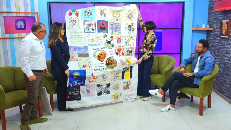 Lienzo mostrado durante el espacio de Corporación Martín por la Vida en Matinal Nuestra Casa de Canal 9 Bío Bío Telelvisión, en la imagen se ve a una conductora y dos invitados sosteniendo un bordado con mensajes