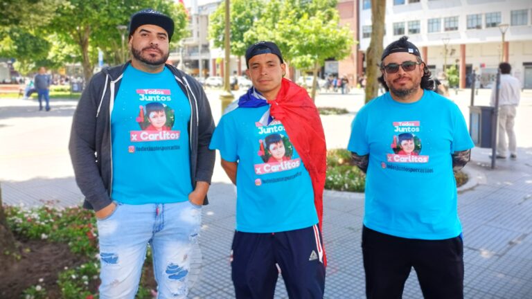 TODOS JUNTOS POR CARLITOS, EN LA FOTO SE VE AL PADRE Y TIOS DEL PEQUEÑO CARLITOS CON UNA BANDERA CHILENA PUESTA, FOTOGRAFÍA TOMADA EN PLAZA INDEPENDENCIA DE CONCEPCIÓN